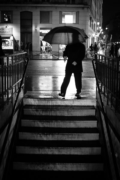 man with umbrella walking down stairs
