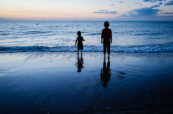 silhouette kids at the beach blue-hour lighting