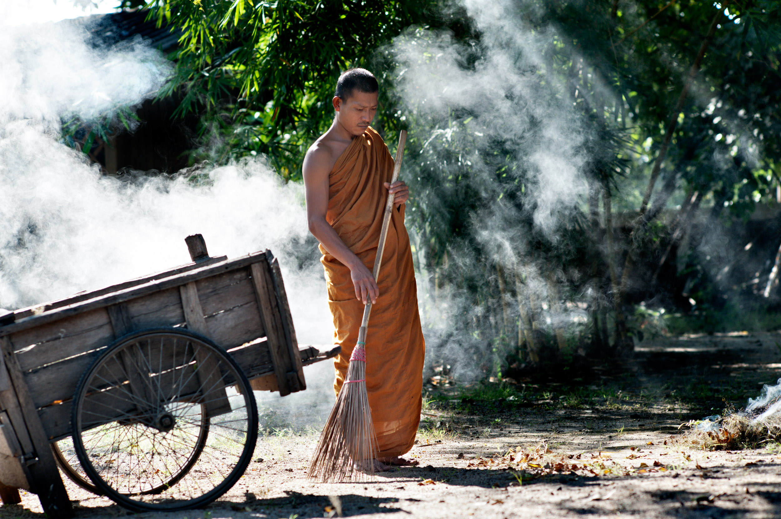 a monk sweeping leaves portrait photography idea