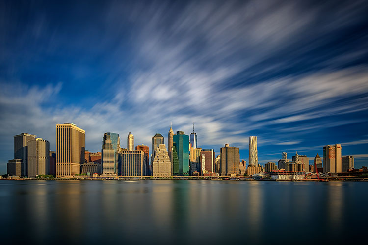 NYC skyline with stretchy clouds and peaceful water